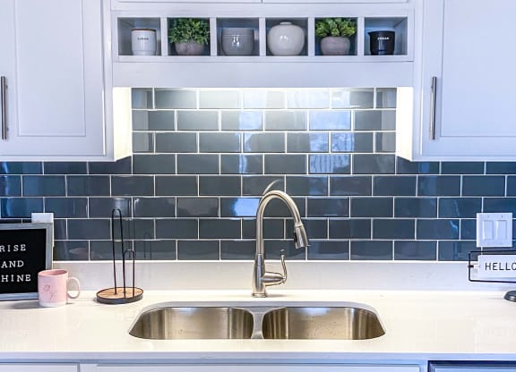 a kitchen sink with white cabinets and blue tile  at Timber Ridge, Forest Lake, MN, 55025