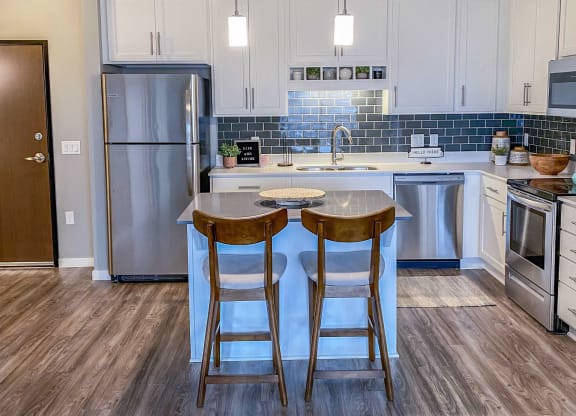 a kitchen with stainless steel appliances and a island with two stools  at Timber Ridge, Minnesota