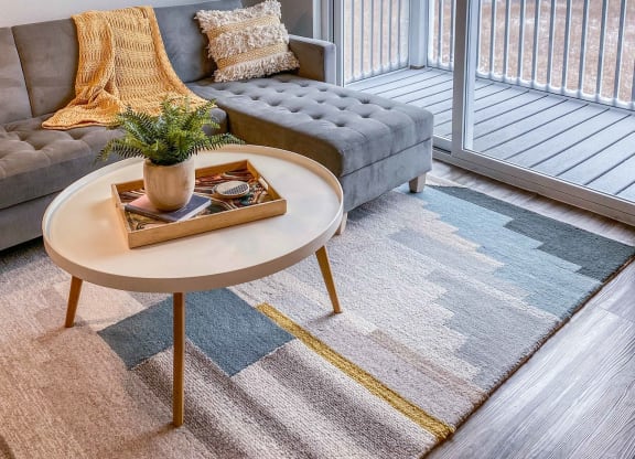 a living room with a couch and a table and a balcony  at Timber Ridge, Forest Lake