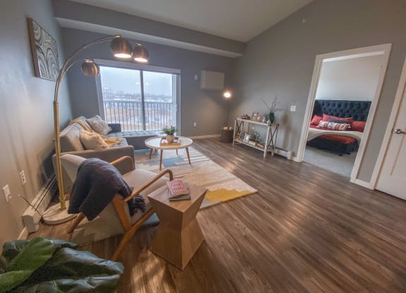 a living room with a couch and a chair and a floor lamp  at Timber Ridge, Forest Lake, 55025