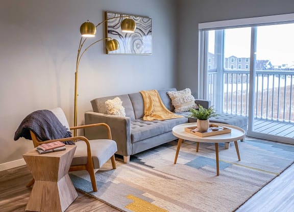 a living room with a couch and a large window  at Timber Ridge, Forest Lake, MN, 55025