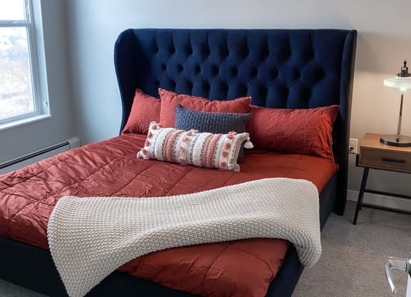 a bedroom with a bed with red sheets and pillows  at Timber Ridge, Minnesota