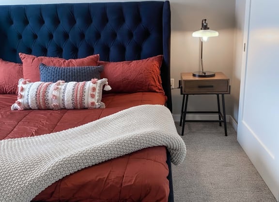 a bedroom with a bed and a nightstand with a lamp  at Timber Ridge, Forest Lake, MN, 55025