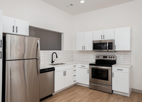 A modern kitchen with a stainless steel refrigerator and oven.at Converge KC Uptown, Kansas City, 64111