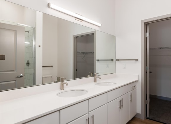 A bathroom with a white counter top and a sink.at Converge KC Uptown, Missouri, 64111