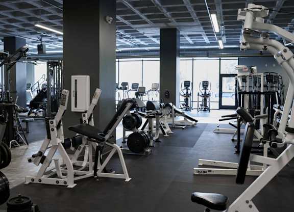 A gym with a variety of equipment including weights and weight machines.at Converge KC Uptown, Kansas City, MO