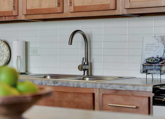 a kitchen with wooden cabinets and a sink at Parkhaus Apartments, Lincoln, NE 68508