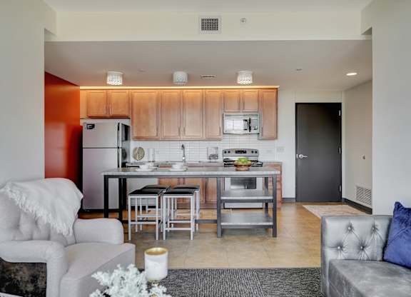 a living room with a kitchen with a island and a couch at Parkhaus Apartments, Lincoln, NE