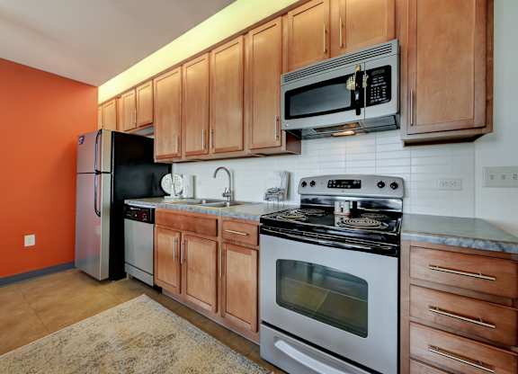 a kitchen with stainless steel appliances and wooden cabinets at Parkhaus Apartments, Lincoln