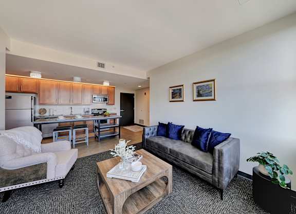 a living room with a couch and a coffee table and a kitchen at Parkhaus Apartments, Lincoln