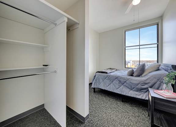 a bedroom with a bed and a closet and a window at Parkhaus Apartments,Nebraska