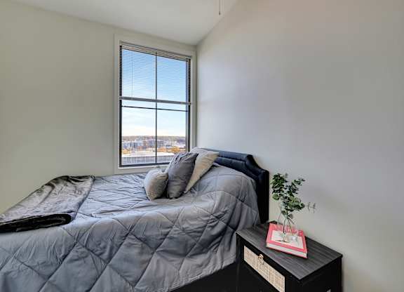 an empty bedroom with a bed and a window at Parkhaus Apartments, Lincoln, Nebraska