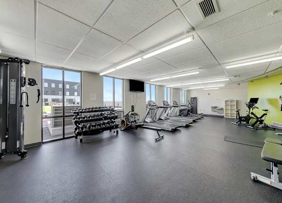 a gym with cardio equipment and weights on the floor at Parkhaus Apartments,Nebraska 68508