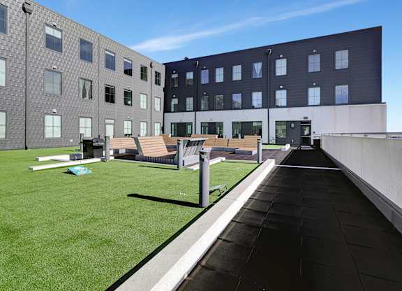 the roof terrace of a building with grass and benches at Parkhaus Apartments, Lincoln, 68508