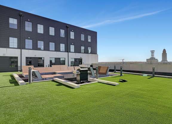 the rooftop patio on the fifth floor of a building with lawn and lounge furniture at Parkhaus Apartments, Lincoln, NE 68508
