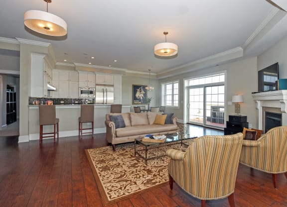 a living room with a couch and chairs and a kitchen
