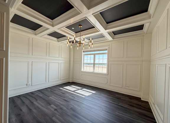 A room with a window and a chandelier.