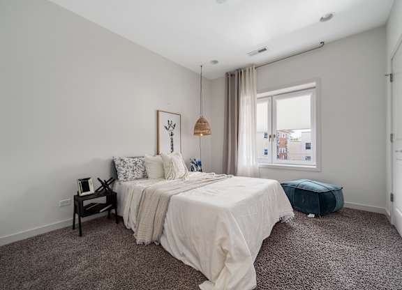 A bedroom with a large bed and a window.