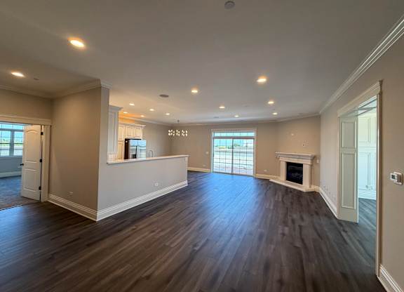 A spacious living room with hardwood floors and a fireplace.