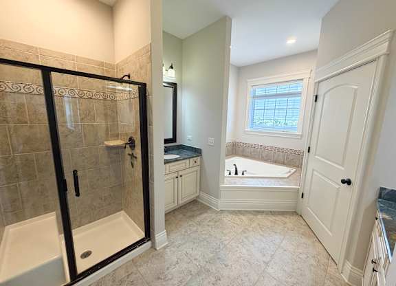 A bathroom with a walk-in shower and a bathtub.