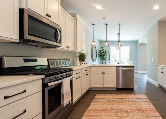 a kitchen with stainless steel appliances and white cabinets at Countryside Townhomes, Illinois