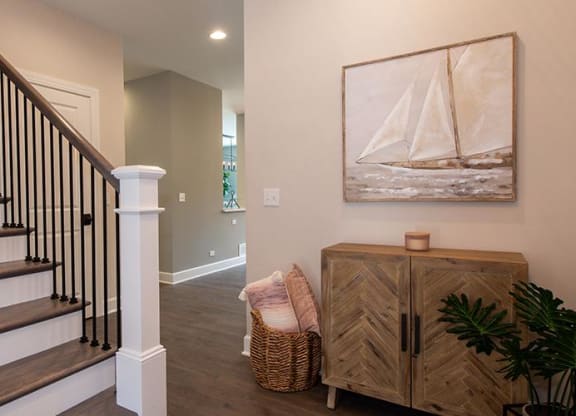 a living room with a staircase and a painting on the wall at Countryside Townhomes, Illinois, 60525