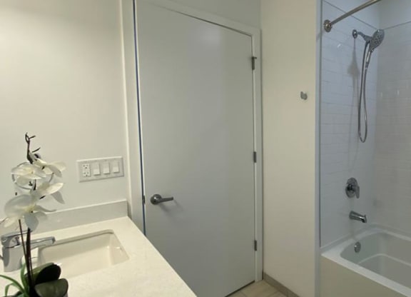 a white bathroom with a shower and a sink at Highwood 546, Highwood