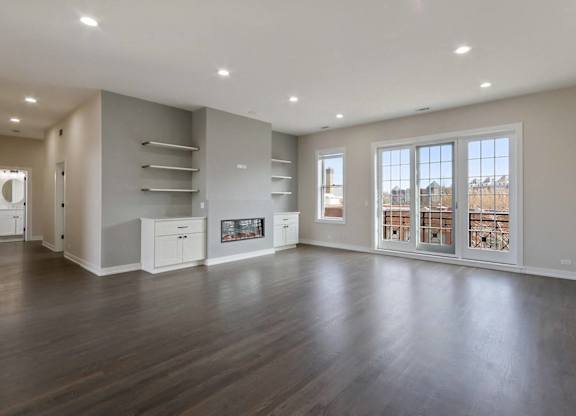 an empty living room with a fireplace and a large window