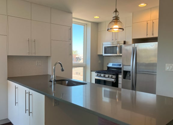a kitchen with a large island and stainless steel appliances