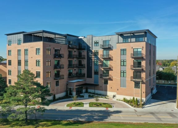a brick apartment building with balconies and a sidewalk