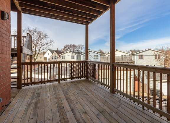 the deck of a home with a view of a yard and houses