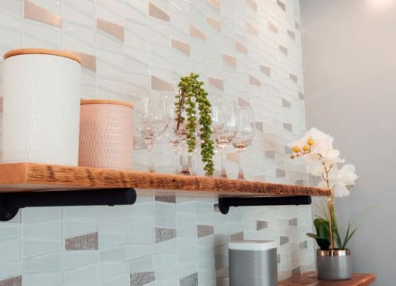 a shelf with wine glasses and flowers on it at Barrington 101, Chicago
