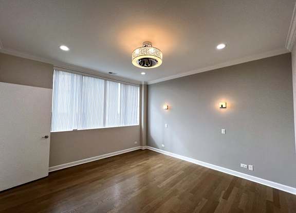 a living room with wood flooring and a large window