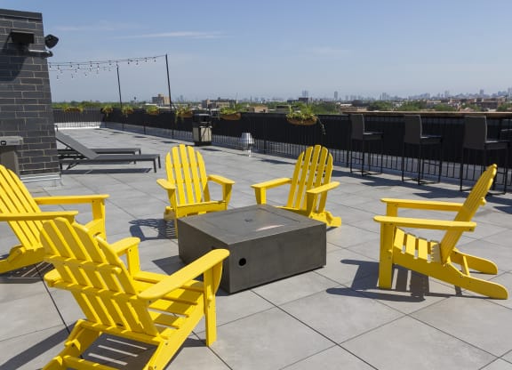 a group of yellow chairs around a fire pit on top of a roof at Talman 1554, Illinois