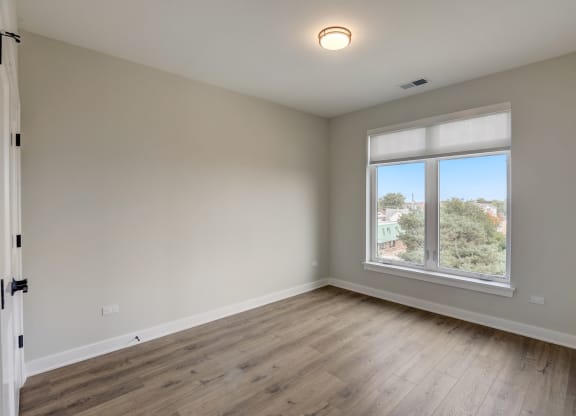 an empty room with wood floors and a window