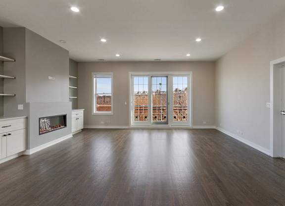 an empty living room with a fireplace and a window