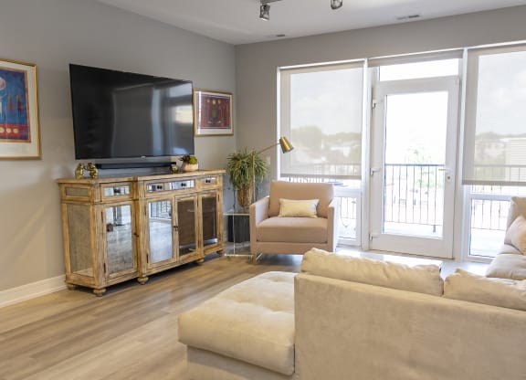 a living room with a couch and a tv and a balcony
