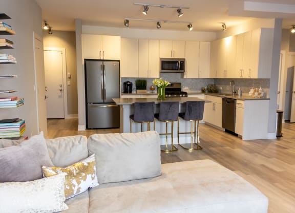 a kitchen with stainless steel appliances and a living room with a couch