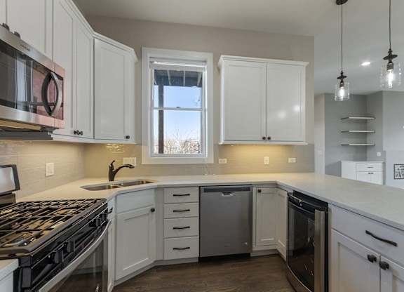 a kitchen with white cabinets and a stove and a window