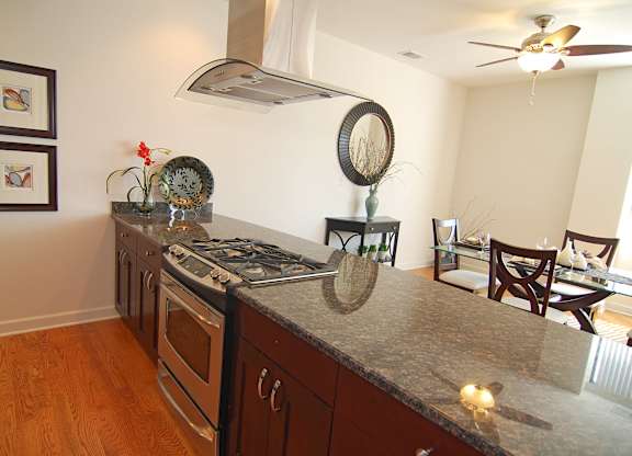 a kitchen with a granite counter top and a dining room with a table and chairs