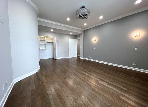 a living room with a hard wood floor and grey walls