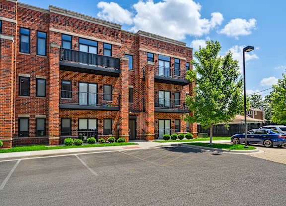 A large brick building with a parking lot in front.