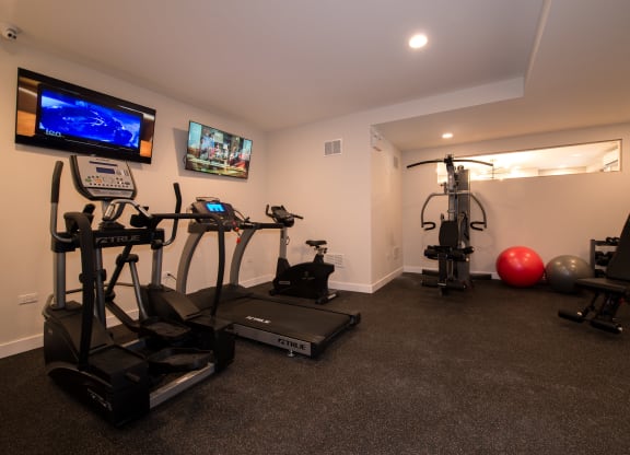 a home gym with exercise equipment and a tv