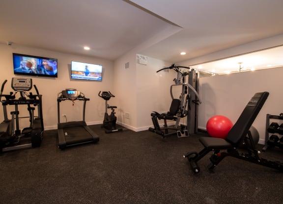 a home gym with exercise equipment and a tv