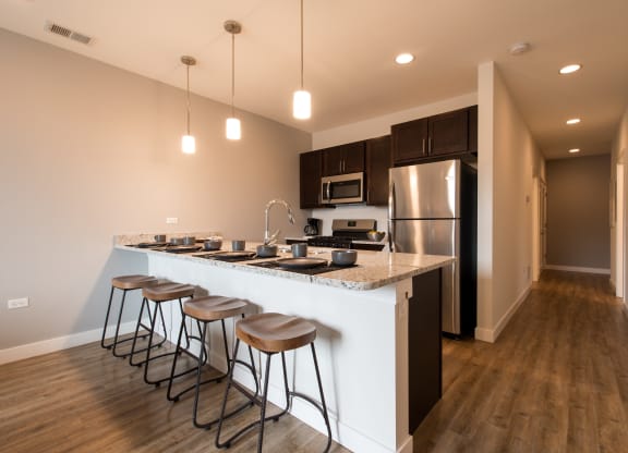 a kitchen with a large island with four stools