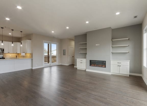 an open living room with a fireplace and a kitchen