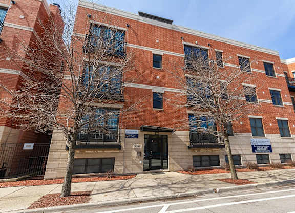 a brick building with two trees in front of it