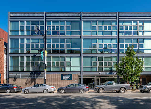 A modern building with a parking lot in front of it.