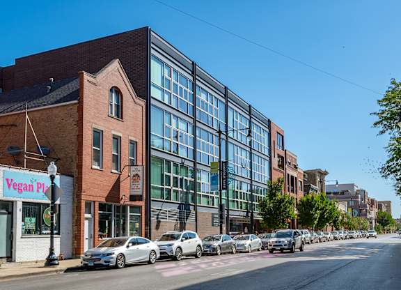 A street view with a vegan pizza shop on the corner.
