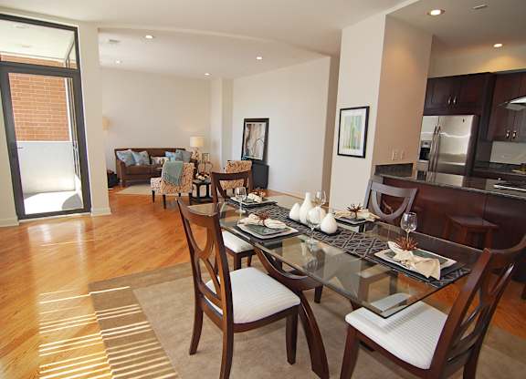 a dining room and living room with a glass table and chairs